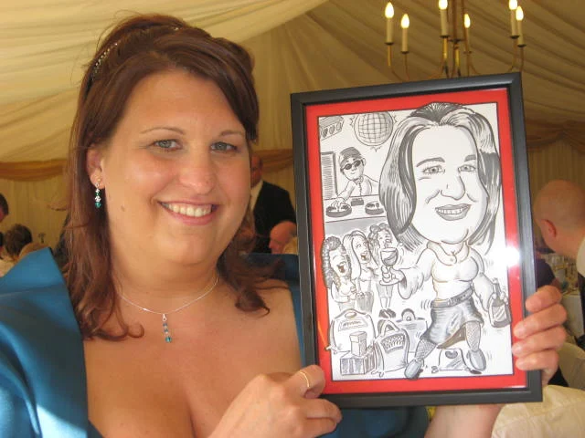 Wedding guest holding her framed caricature by Jules